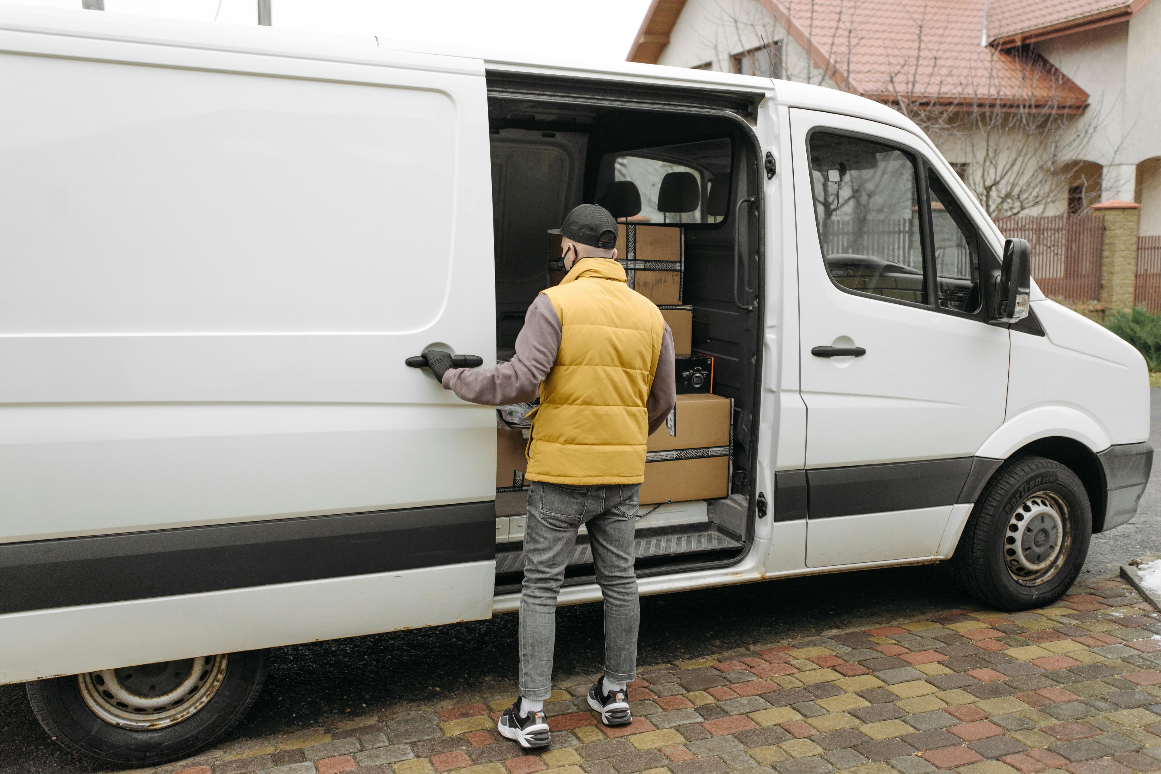 Courier completing a delivery stop beside a van
