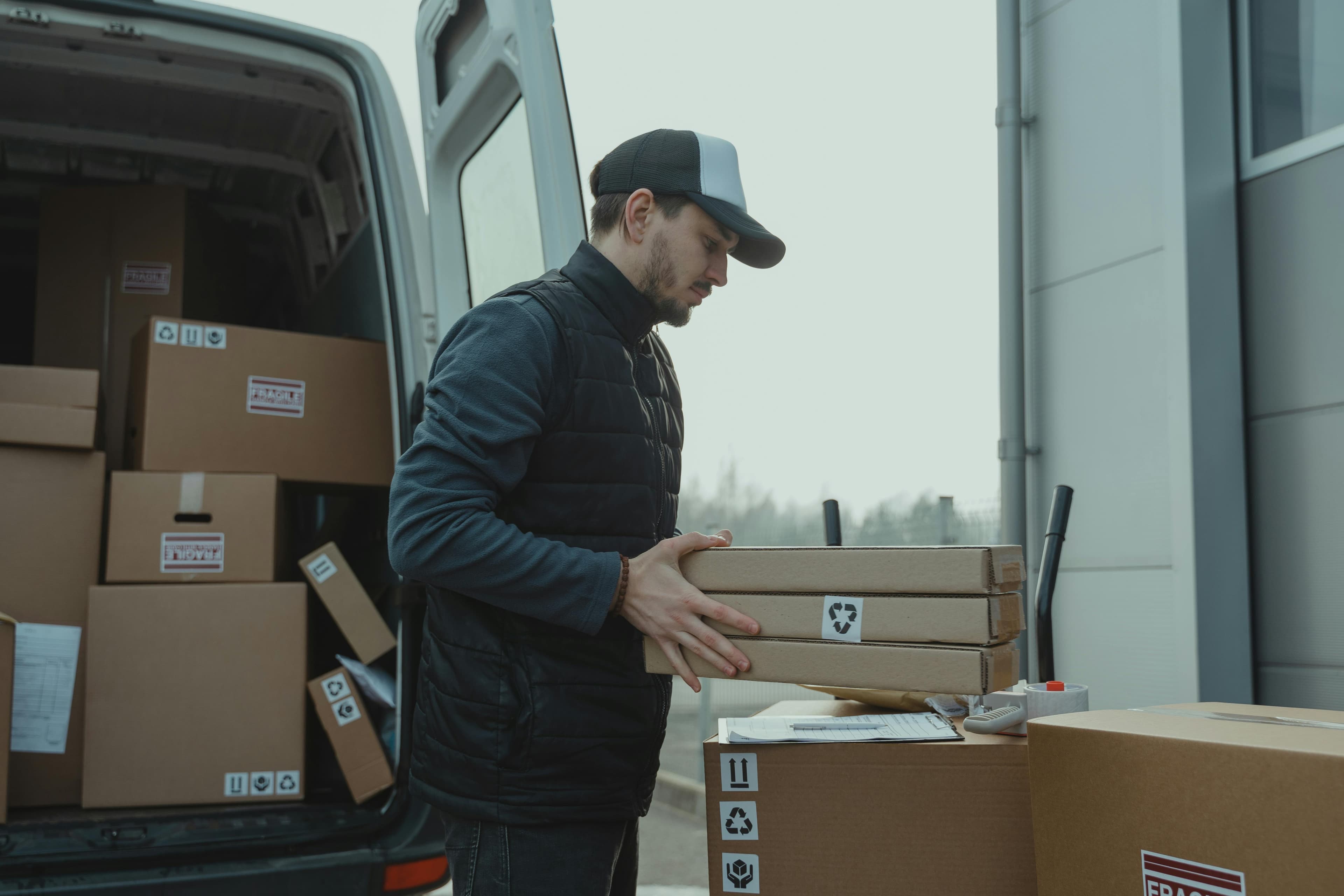 Courier sorting parcels beside a van